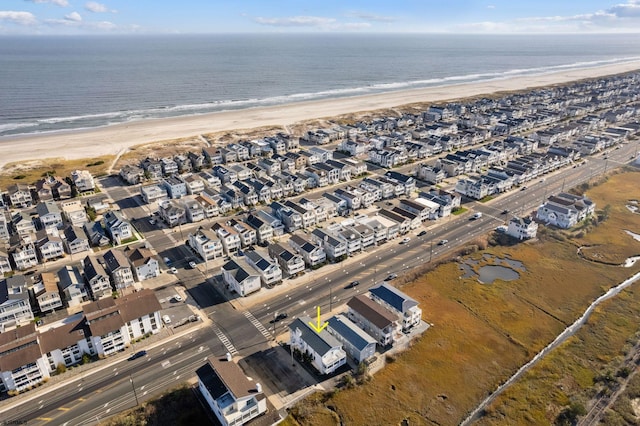 birds eye view of property with a water view and a beach view