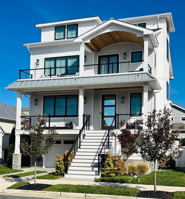 view of front of property with a balcony, a front yard, and a garage