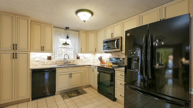 kitchen featuring cream cabinets, hanging light fixtures, black appliances, and sink