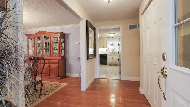 hall featuring ornamental molding, a textured ceiling, wood-type flooring, and sink