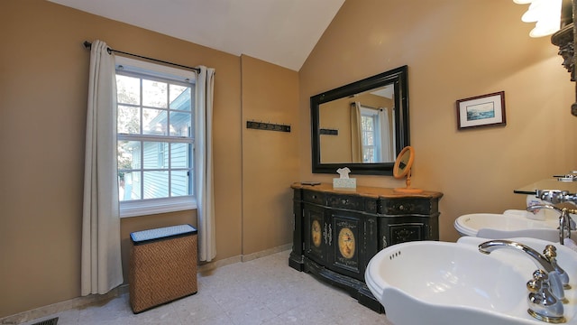 bathroom featuring vanity and lofted ceiling