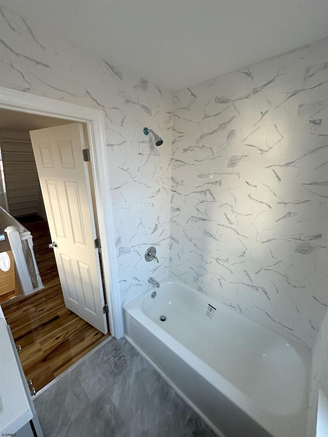 bathroom with hardwood / wood-style floors and shower / washtub combination