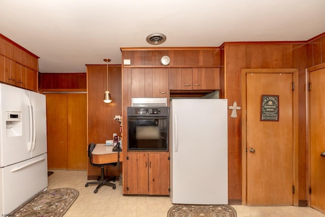 kitchen with oven, white fridge, wooden walls, and white refrigerator with ice dispenser