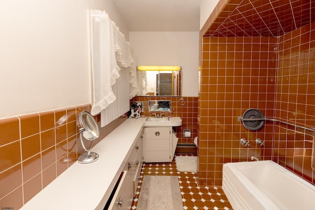 bathroom with vanity, tile walls, and a bath