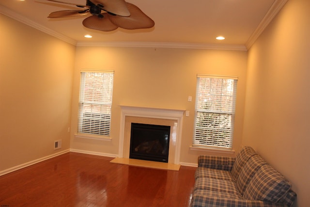 unfurnished living room featuring dark wood-type flooring, ceiling fan, a healthy amount of sunlight, and ornamental molding