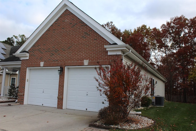 view of side of home with central air condition unit, a lawn, and a garage