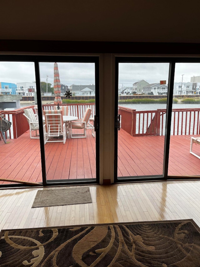 doorway to outside featuring hardwood / wood-style floors and a water view