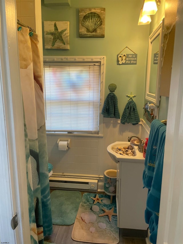 bathroom featuring hardwood / wood-style flooring, vanity, and a baseboard heating unit