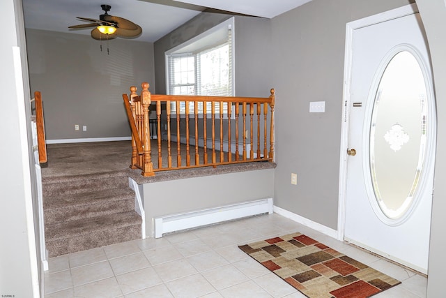 foyer entrance featuring a baseboard heating unit, light colored carpet, and ceiling fan