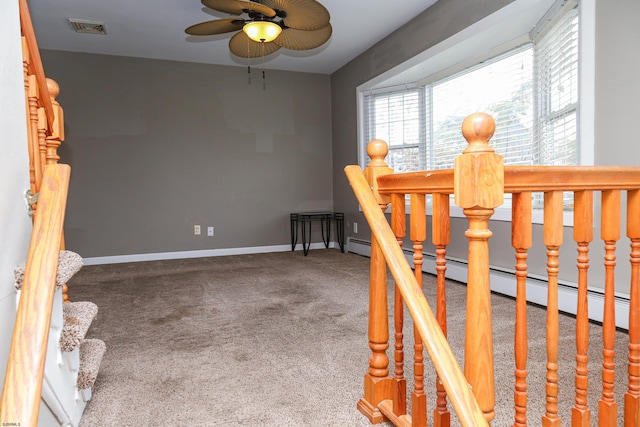 stairs featuring ceiling fan and carpet floors