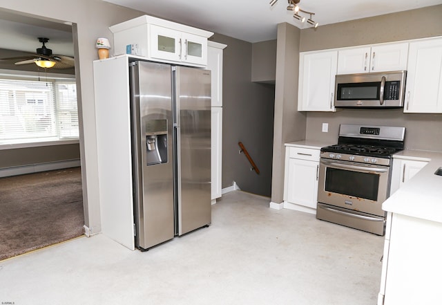 kitchen featuring light colored carpet, white cabinets, baseboard heating, ceiling fan, and appliances with stainless steel finishes