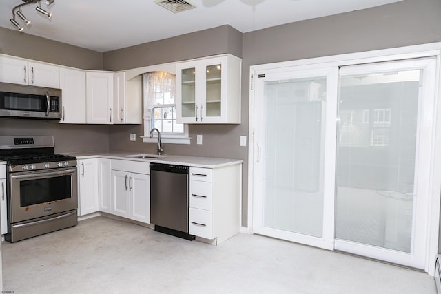 kitchen with white cabinets, appliances with stainless steel finishes, and sink