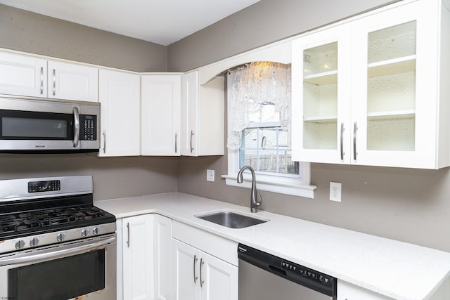 kitchen featuring stainless steel appliances, white cabinets, and sink