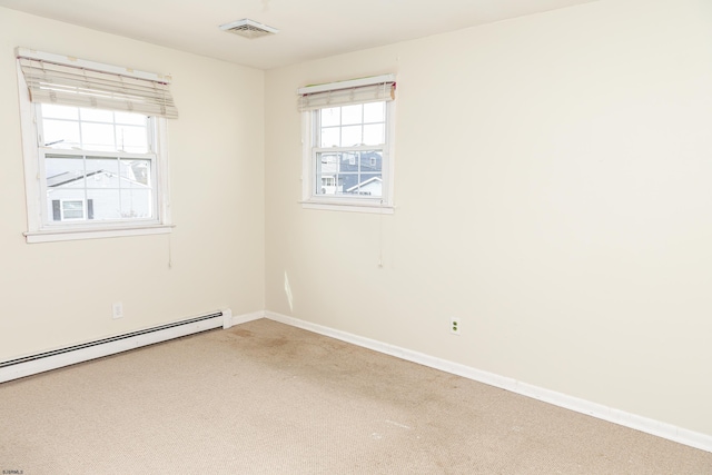 spare room with a baseboard heating unit and carpet