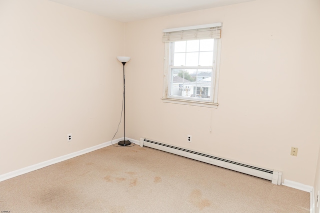 spare room with a baseboard heating unit and carpet floors