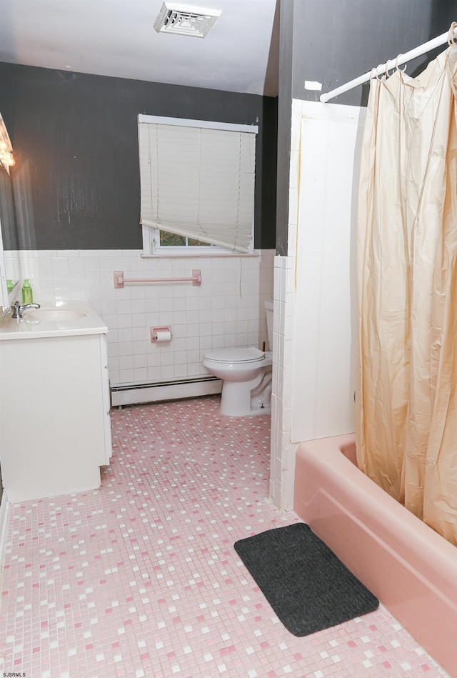 full bathroom with a baseboard radiator, shower / bath combo with shower curtain, toilet, tile walls, and vanity