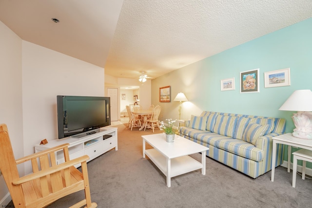 living room featuring a textured ceiling, carpet floors, and ceiling fan