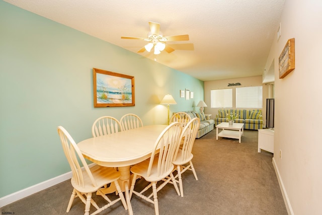 dining area with ceiling fan, dark colored carpet, and a textured ceiling