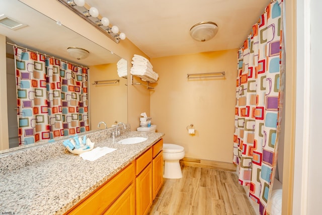 bathroom with toilet, a shower with curtain, vanity, and hardwood / wood-style flooring