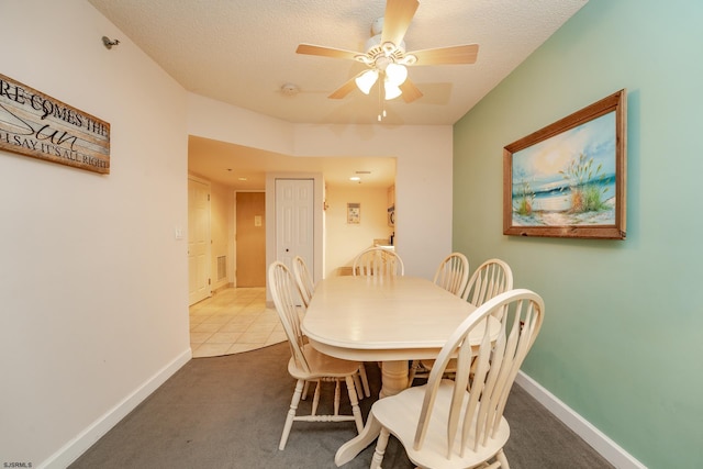 tiled dining room with ceiling fan and a textured ceiling