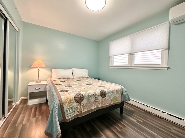 bedroom with a wall mounted AC, baseboard heating, dark hardwood / wood-style floors, and a closet