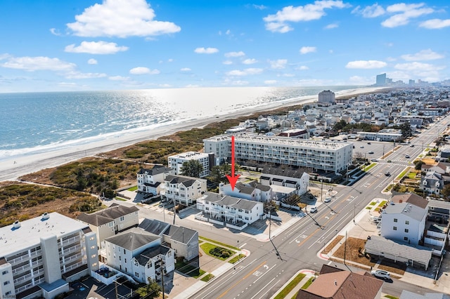 bird's eye view with a water view and a beach view