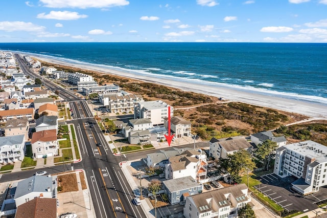 birds eye view of property with a water view and a beach view