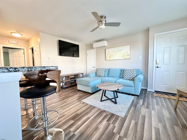 living room with dark wood-type flooring, ceiling fan, and a wall mounted AC