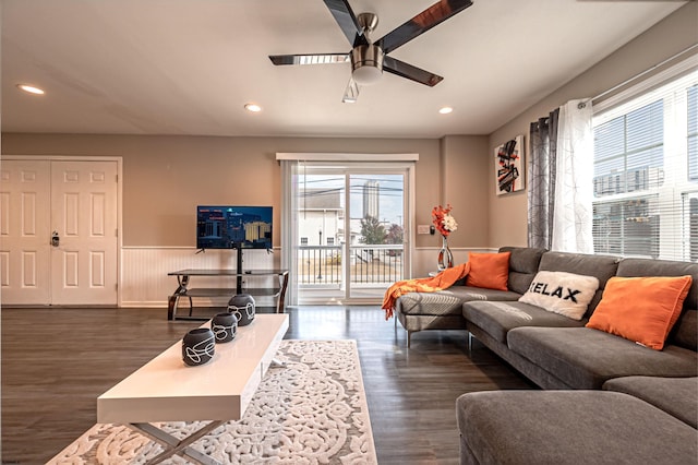 living room featuring ceiling fan and dark hardwood / wood-style floors