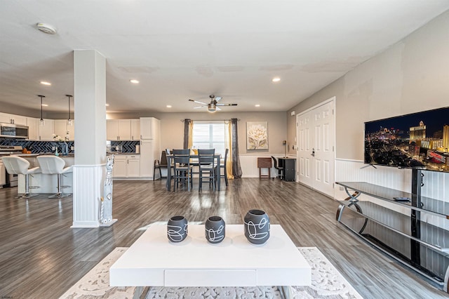 living room with dark hardwood / wood-style floors and ceiling fan