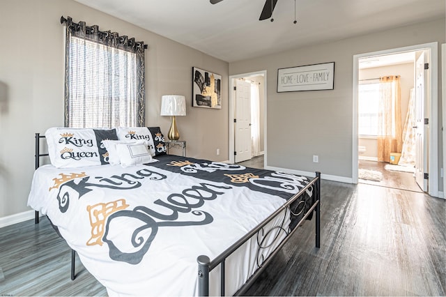 bedroom with dark wood-type flooring, ceiling fan, and connected bathroom