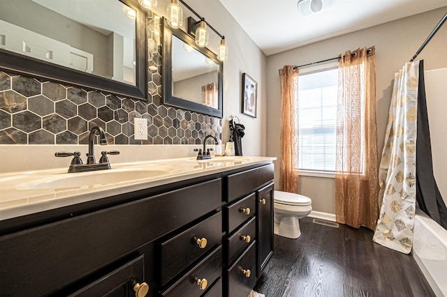 full bathroom with shower / bath combo, toilet, decorative backsplash, hardwood / wood-style flooring, and vanity