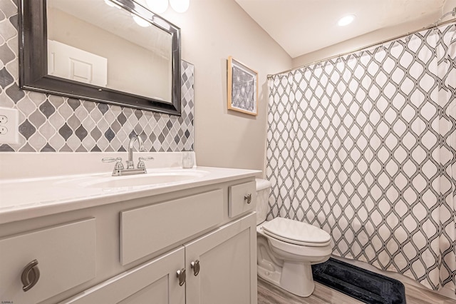 bathroom featuring walk in shower, vanity, decorative backsplash, hardwood / wood-style flooring, and toilet