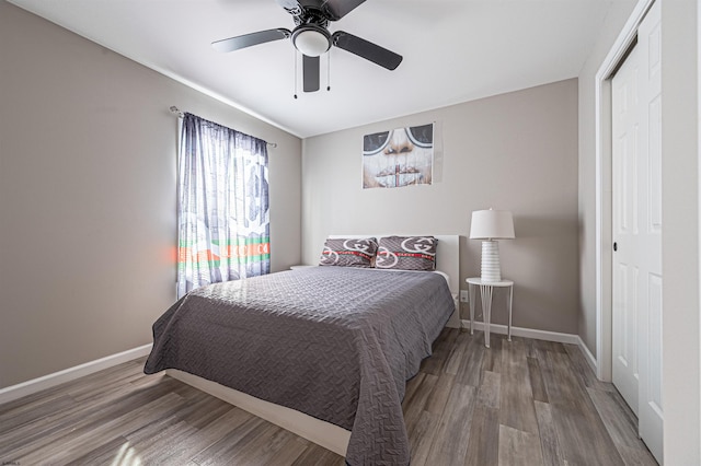 bedroom with a closet, wood-type flooring, and ceiling fan