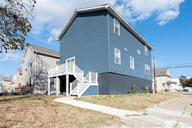 view of property exterior with a yard and a deck