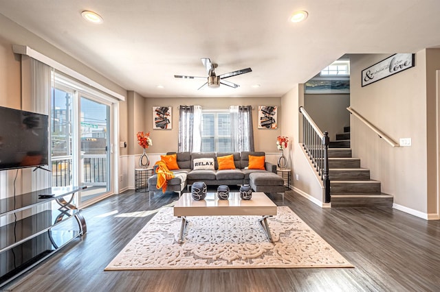 living room featuring dark wood-type flooring, ceiling fan, and a healthy amount of sunlight