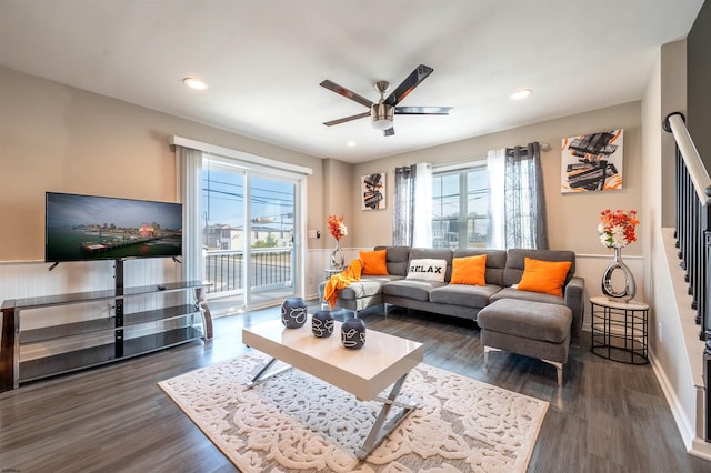 living room with plenty of natural light, dark wood-type flooring, and ceiling fan