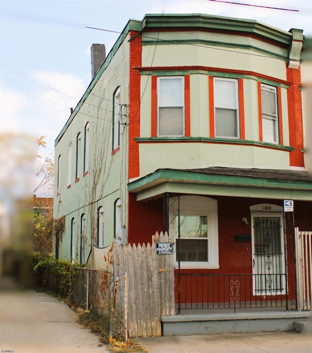1828 Reverend J J Walters Ave, Atlantic City, NJ 08401 - view of front of house featuring a porch, fence, and a chimney