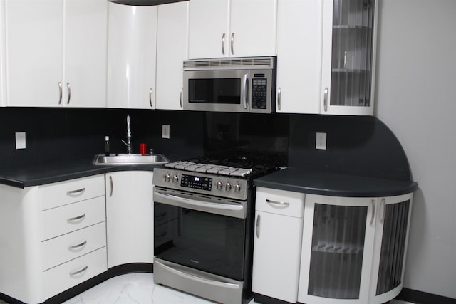 kitchen with white cabinets, sink, decorative backsplash, and appliances with stainless steel finishes