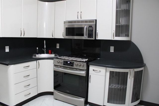1828 Reverend J J Walters Ave, Atlantic City, NJ 08401 - kitchen with appliances with stainless steel finishes, a sink, dark countertops, light marble finish floors, and white cabinets