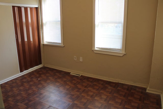 empty room featuring dark parquet flooring