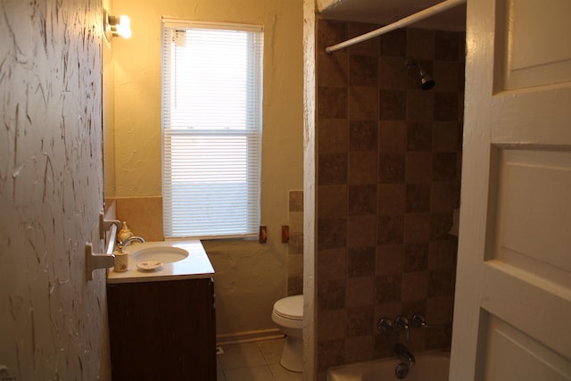 full bathroom with toilet, vanity, tiled shower / bath combo, and tile patterned floors