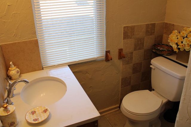 1828 Reverend J J Walters Ave, Atlantic City, NJ 08401 - bathroom with healthy amount of natural light, toilet, tile walls, vanity, and a textured wall
