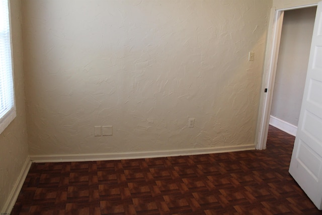 spare room with dark parquet floors