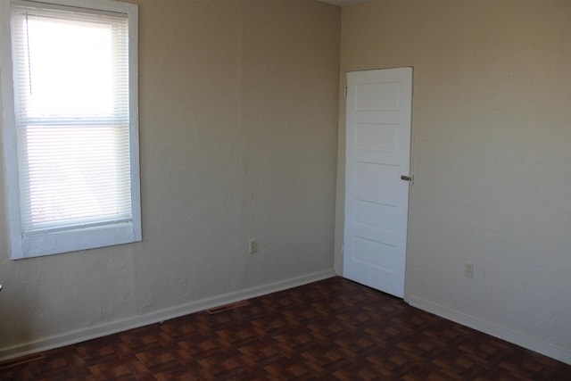 spare room featuring dark parquet floors