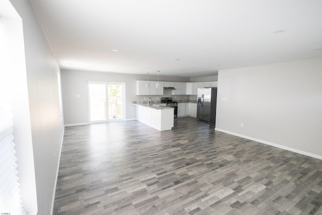 unfurnished living room featuring sink and hardwood / wood-style flooring