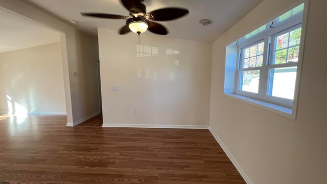 empty room featuring dark hardwood / wood-style flooring and ceiling fan