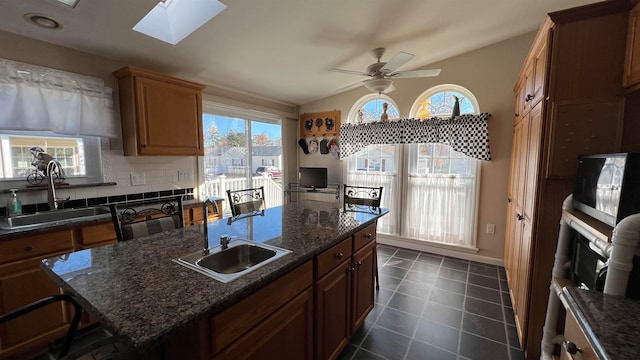 kitchen featuring a kitchen breakfast bar, plenty of natural light, and sink