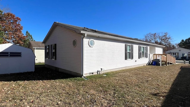 view of home's exterior with a storage shed and a lawn