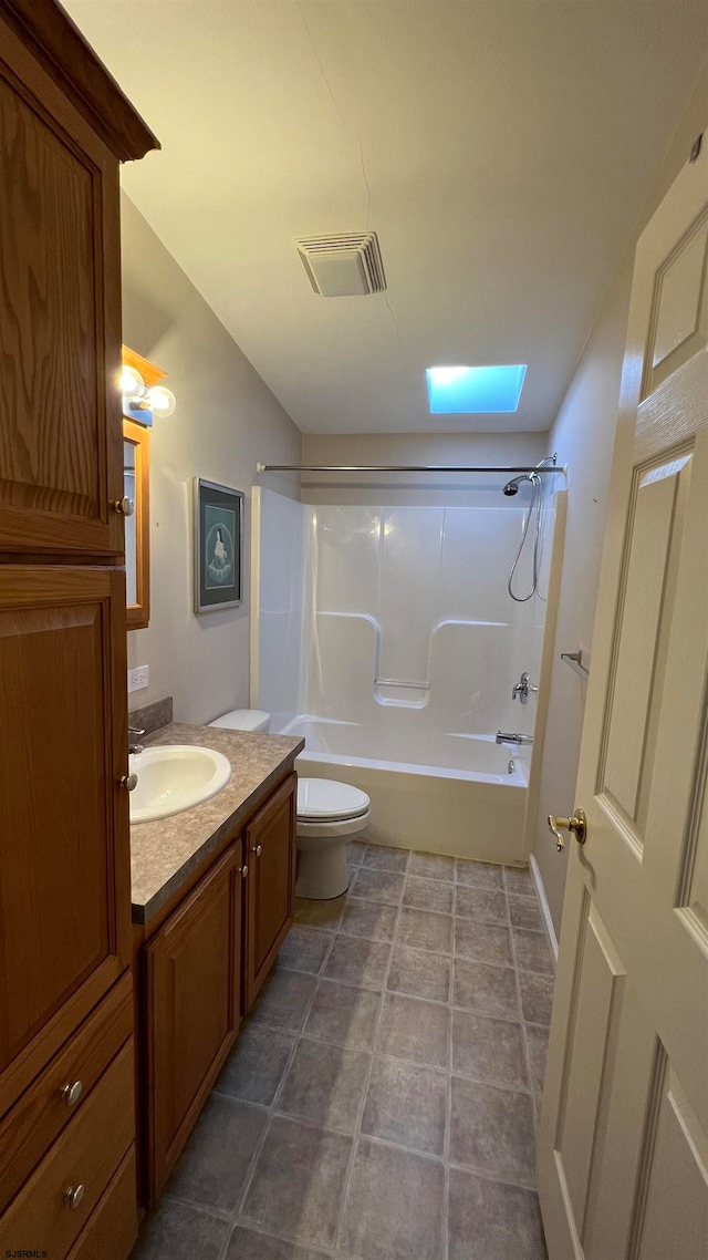 full bathroom featuring toilet, tile patterned floors, vanity, bathing tub / shower combination, and a skylight